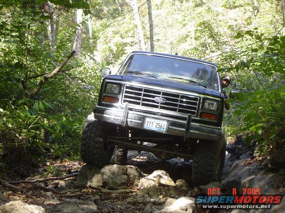 Black 1980s Ford Bronco navigating rocky trail