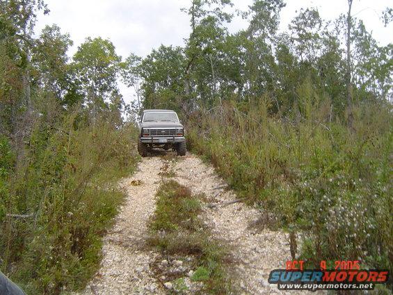 1986 Ford Bronco on a wooded gravel road