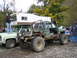 1990 Ford Bronco - Two trucks are parked side-by-side, one with a camper and the other heavily modified for off-roading.