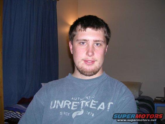 Man wearing a grey t-shirt with text, indoors