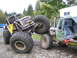 1990 Ford Bronco - Custom rock crawlers are shown interacting in an outdoor setting with trees and a trailer in the background.