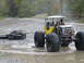 1990 Ford Bronco - Custom off-road buggy tows scrap metal through a wet, muddy area.