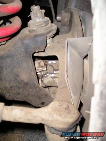 Close-up of vehicle suspension component with red spring