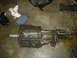 1991 Ford Crown Victoria - A transmission part is shown on a concrete floor, accompanied by cleaning supplies and other automotive components.