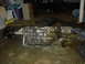 1991 Ford Crown Victoria - Transmission and differential assembly resting on a garage floor with various items in the background.