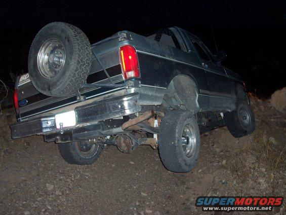 1996 Ford Bronco on uneven terrain, rear view with spare tire mounted