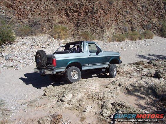 1996 Ford Bronco, rear 3/4 view, two-tone green and silver, off-road