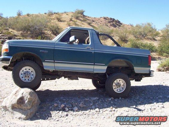 Two-tone green and silver Ford Bronco on a rocky, desert terrain