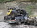 1990 Ford Bronco - An off-road buggy is precariously balanced on a damaged pickup truck, with another severely damaged vehicle nearby.