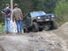 1990 Ford Bronco - Modified Ford Bronco navigates a steep, rocky incline with two onlookers observing.