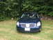 2005 Nissan Maxima - Front view of a dark blue sedan with a chrome grille and a sunroof.