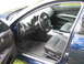 2005 Nissan Maxima - The interior of a blue sedan, showing the driver's seat, dashboard, and center console.