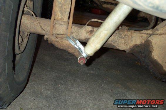 Rear axle assembly with a shock absorber attached by a clamp