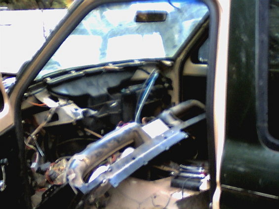 Disassembled car dashboard with exposed wires and ductwork