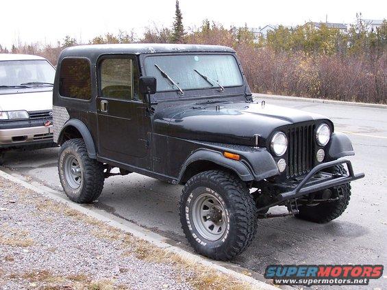 Black 1983 Jeep CJ7 with aftermarket bumper and diamond plate rear fender trim, parked on a roadside