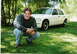 2000 Ford Crown Victoria - A white 2000 Ford Crown Victoria is seen from a 3/4 front angle, parked on grass with a person crouching in front of it.