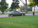 1996 Ford Probe - The side profile of a 1996 Ford Probe is visible parked on a road with houses in the background.