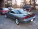 1996 Ford Probe - A gray Ford Probe is parked next to a pink Ford Probe and a pickup truck.