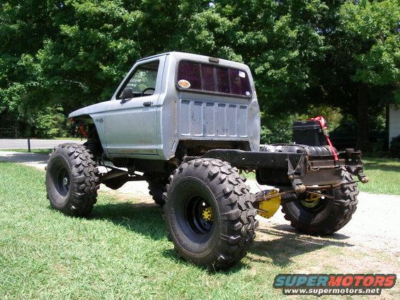 Pickup truck chassis with large off-road tires, lifted suspension, and exposed frame