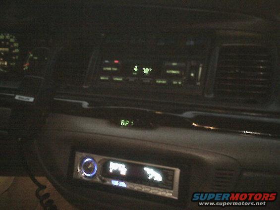 Dashboard interior with aftermarket stereo and digital clock showing 62