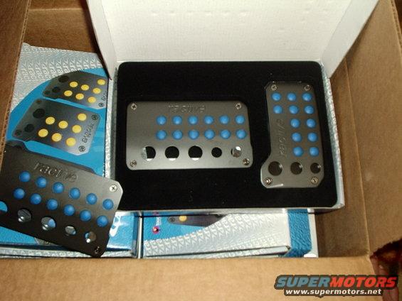 Aftermarket aluminum pedal covers with blue inserts, some in packaging