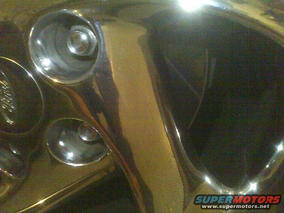 Chrome wheel with visible lug nuts and a faint 'Ford' logo