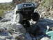 1993 Ford Bronco - A white 1992 Ford Bronco tackles a challenging rocky terrain, demonstrating its off-road capabilities.