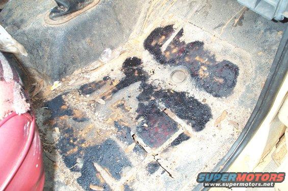 Interior floor pan with rust and dark stains