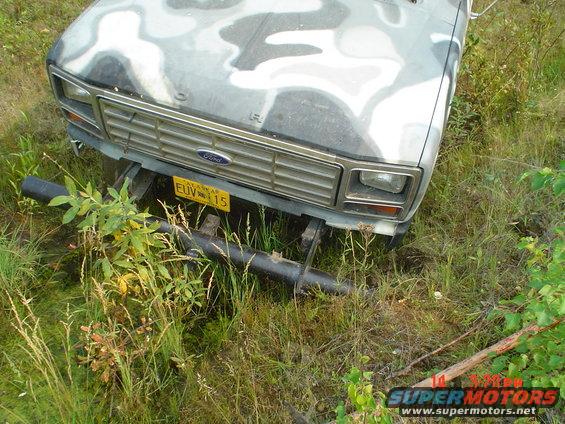 Front view of a 1986 Ford F-150 with camouflage paint and a yellow license plate