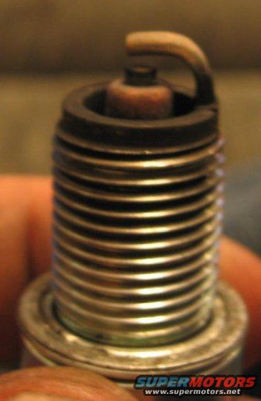 Spark plug with dark deposits on the electrode and insulator