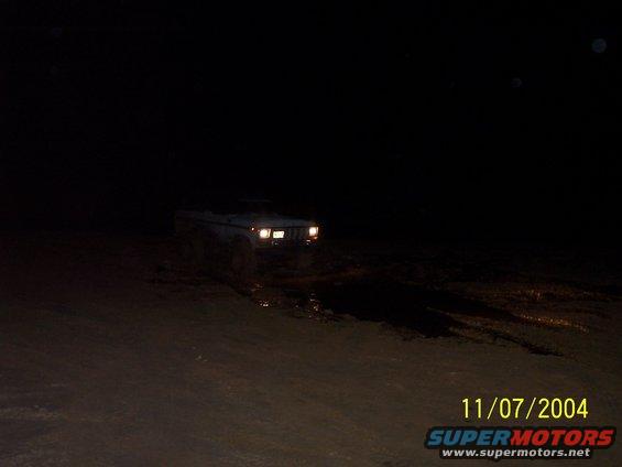 1978 Ford Bronco driving through mud at night