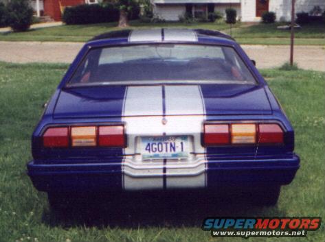 Rear view of a blue 1977 Ford Mustang II with silver racing stripes