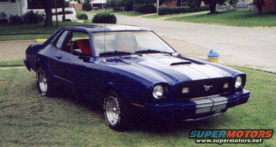 1977 Ford Mustang II coupe, blue with white racing stripes, parked on grass