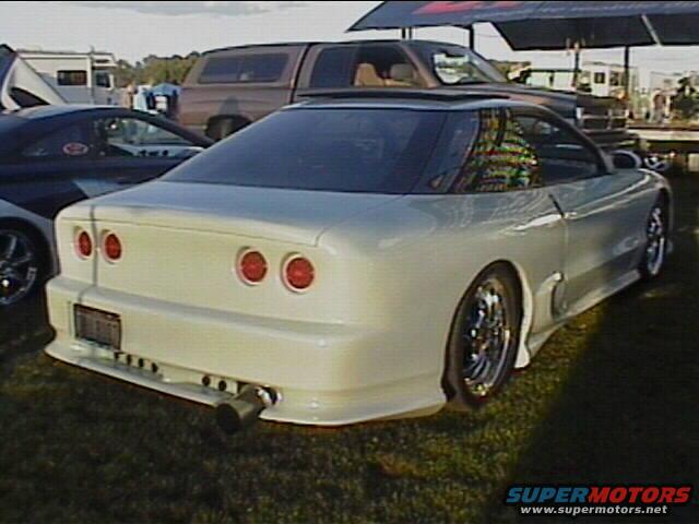 White 1994 Ford Probe with custom rear bumper and large exhaust pipe, seen from the rear