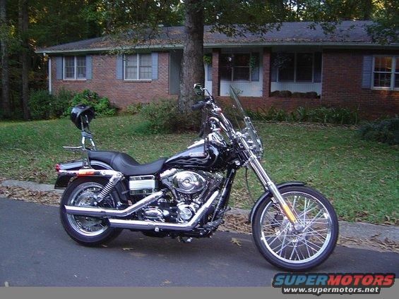 Black Harley-Davidson motorcycle parked on a street in front of a brick house
