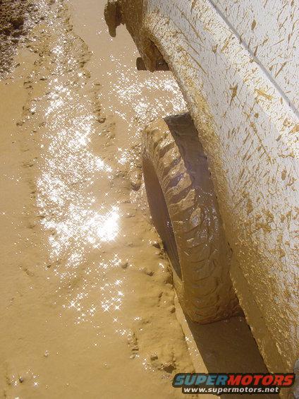 Muddy tire of a vehicle stuck in a mud puddle