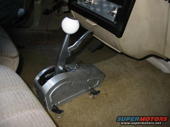 Aftermarket automatic shifter with a white ball knob and chrome lever, installed in a car's carpeted interior