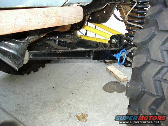 close-up of vehicle's front axle, suspension, and exhaust pipe