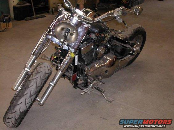 Chrome motorcycle with black seat and engine, front tire visible