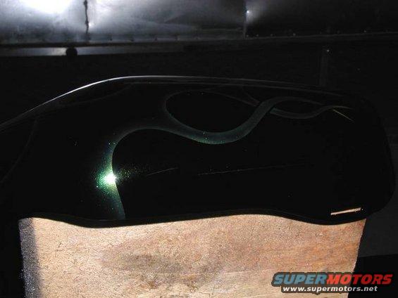 Black motorcycle fuel tank with green flame graphics