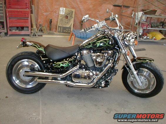 Motorcycle with black and green flame paint job, chrome accents, and custom exhaust