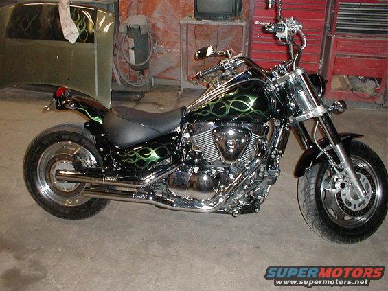 Black motorcycle with green flame graphics, chrome accents, and custom paint