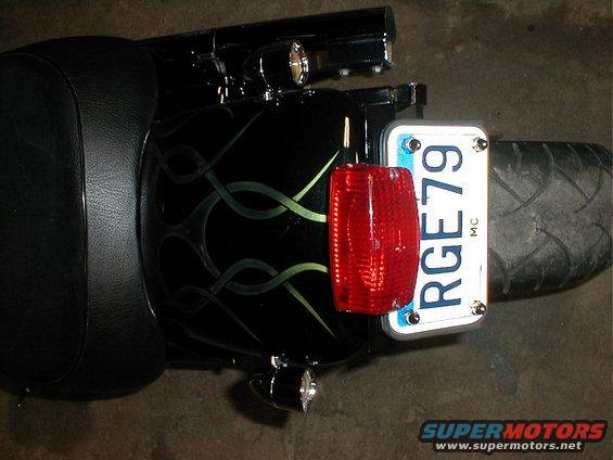 Black motorcycle rear fender with green flames, red taillight, and license plate RGE79 MC