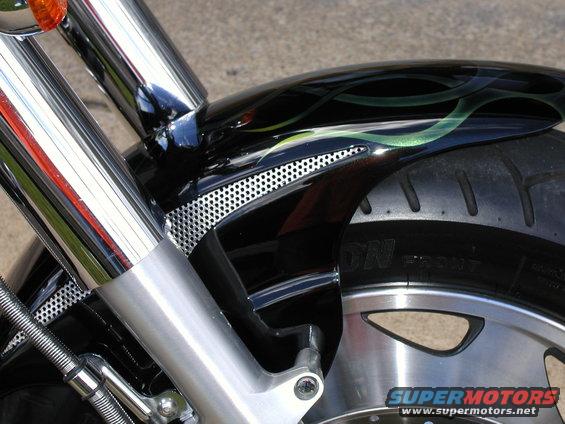 Close-up of a motorcycle's front fender with custom green flames painted on black