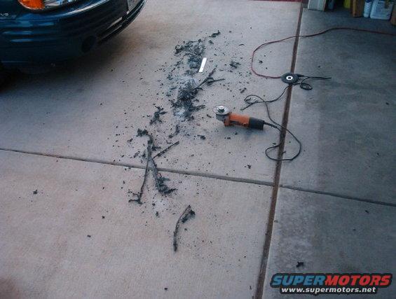 Angle grinder and debris on concrete driveway