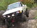 1990 Ford Bronco - This Toyota pickup truck appears to be from the mid-1980s, not a 1990 Ford Bronco, as it navigates a challenging off-road course.