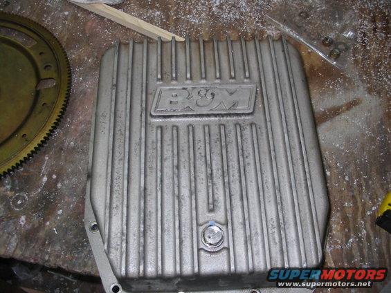 B&M finned aluminum transmission pan with a yellow bolt