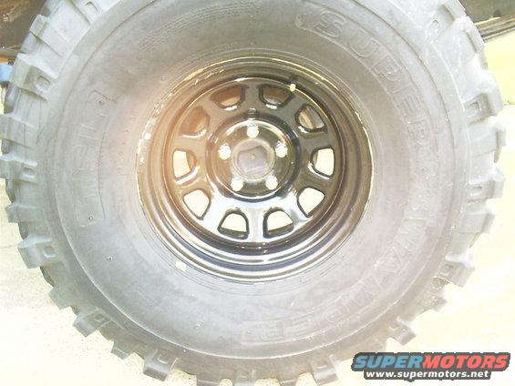 Close-up of a large off-road tire on a black steel rim