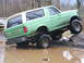 1990 Ford Bronco - This 1990 Ford Bronco is navigating a challenging off-road course with one wheel up on a rock.