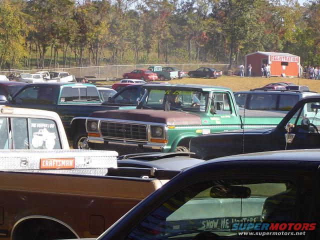 Green 1979 Ford pickup truck with a brown hood, parked at an outdoor event